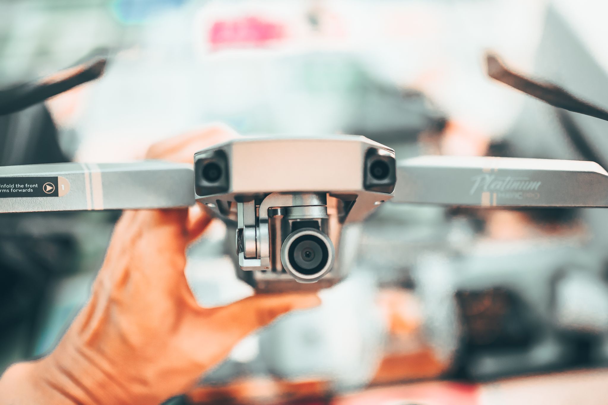 Crop anonymous male photographer using professional flying drone with camera in modern megapolis at daytime