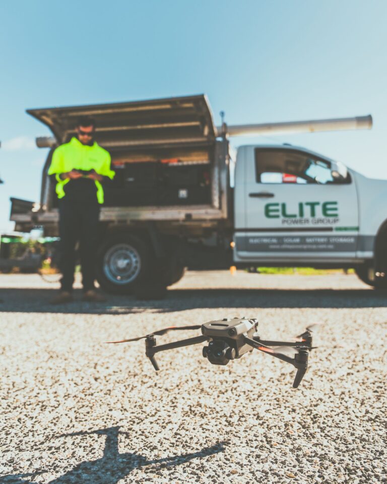 Technician preps drone for flight next to utility truck in New South Wales, Australia.